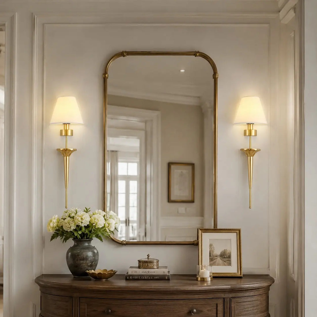 Brass fabric shade wall sconce styled in an entryway