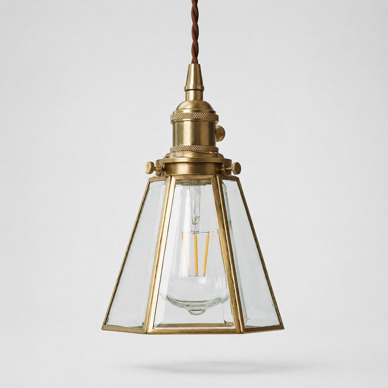 Clear glass pendant light with brass canopy