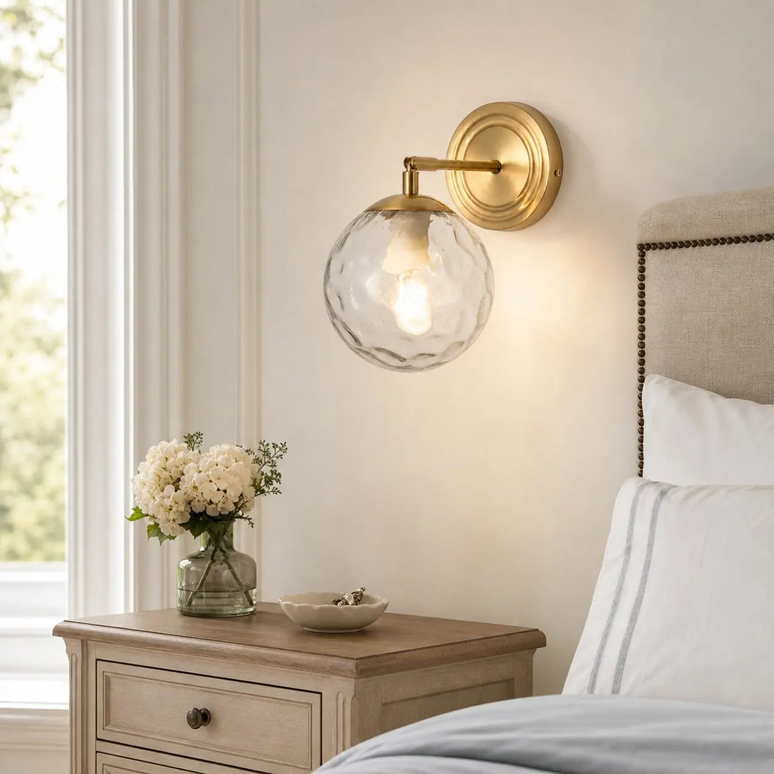 Rippled glass wall lamp above a wood bedside table