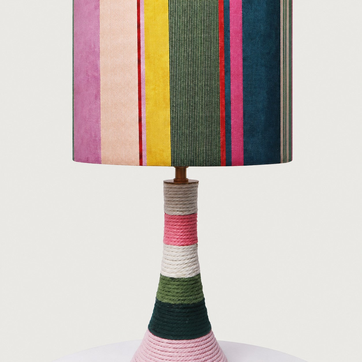 Close view of the colorful striped fabric shade and cotton-wrapped ceramic base