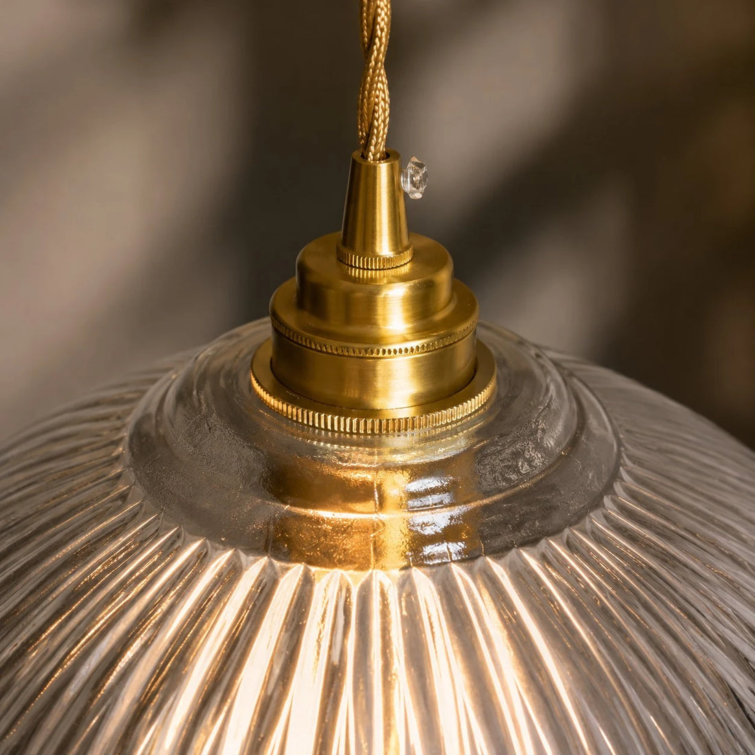 Brass cap and ribbed glass detail of the pendant light