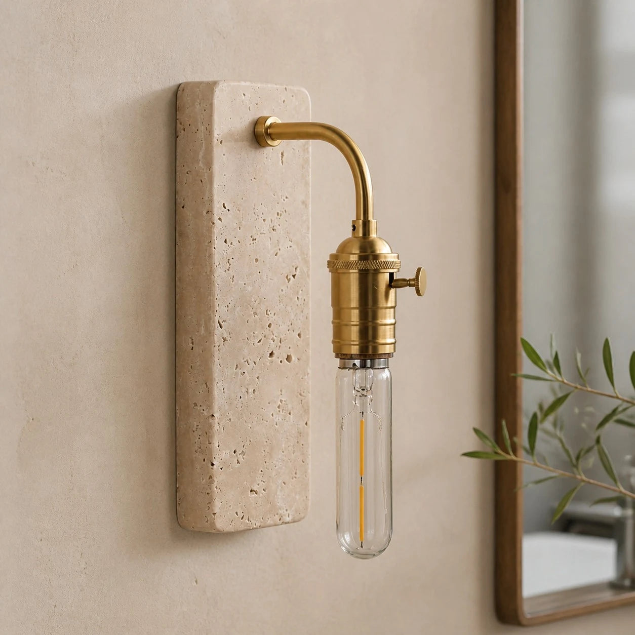 Gold travertine wall sconce installed beside a mirror