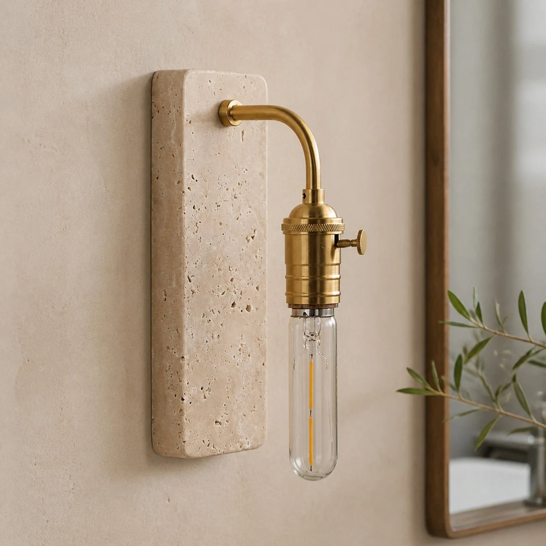 Gold travertine wall sconce installed beside a mirror