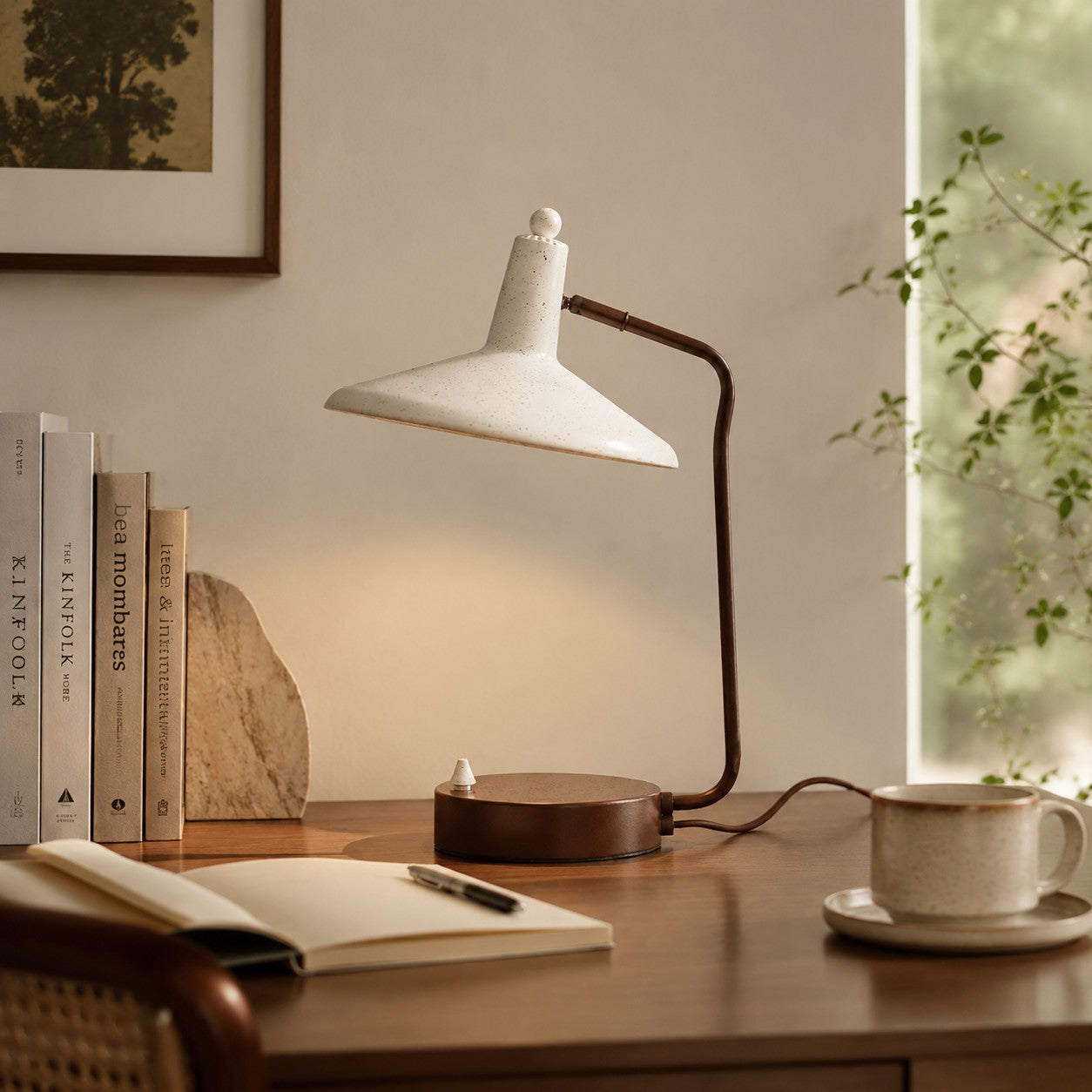 Japanese iron desk lamp beside books and a cup on a wooden study desk