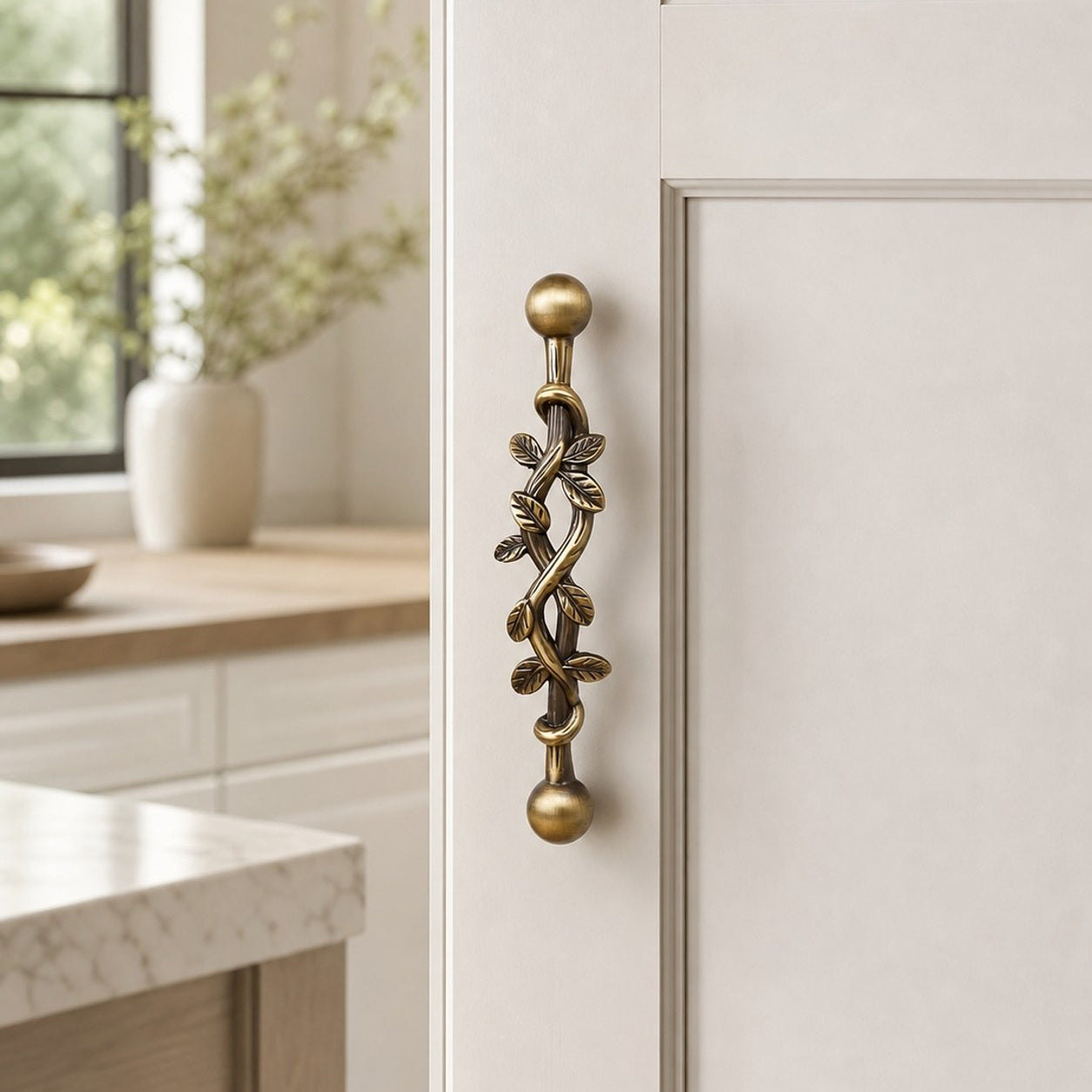 Leaf brass cabinet pull installed on a light cabinet door