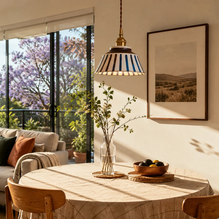Striped ceramic pendant lamp in a sunlit dining nook