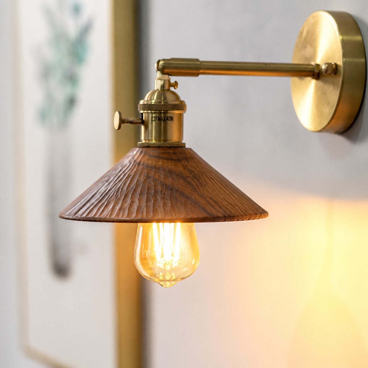 Wood and brass wall sconce casting warm light above a shelf