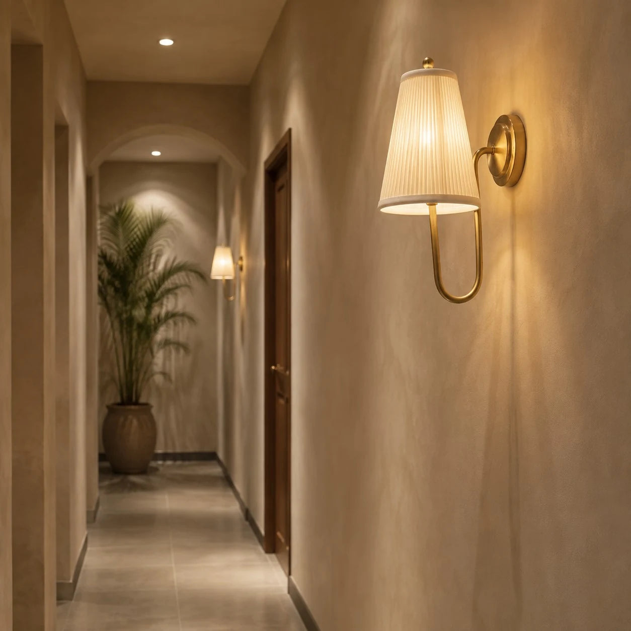 Brass fabric wall sconce lighting a hallway wall