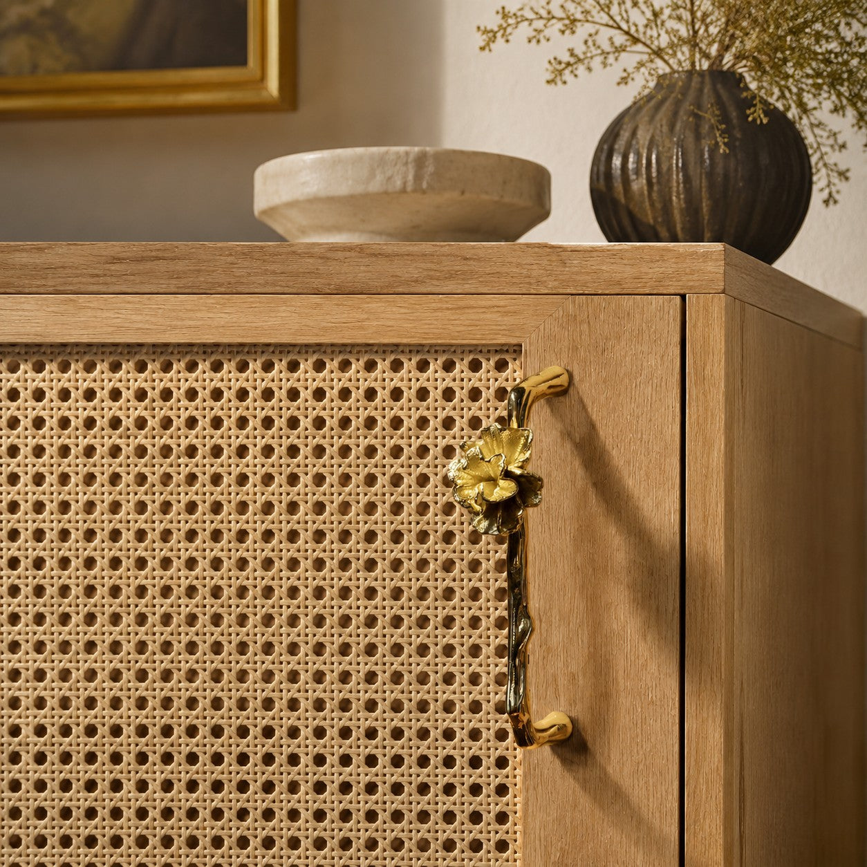 Nature-inspired brass hardware on a cabinet door