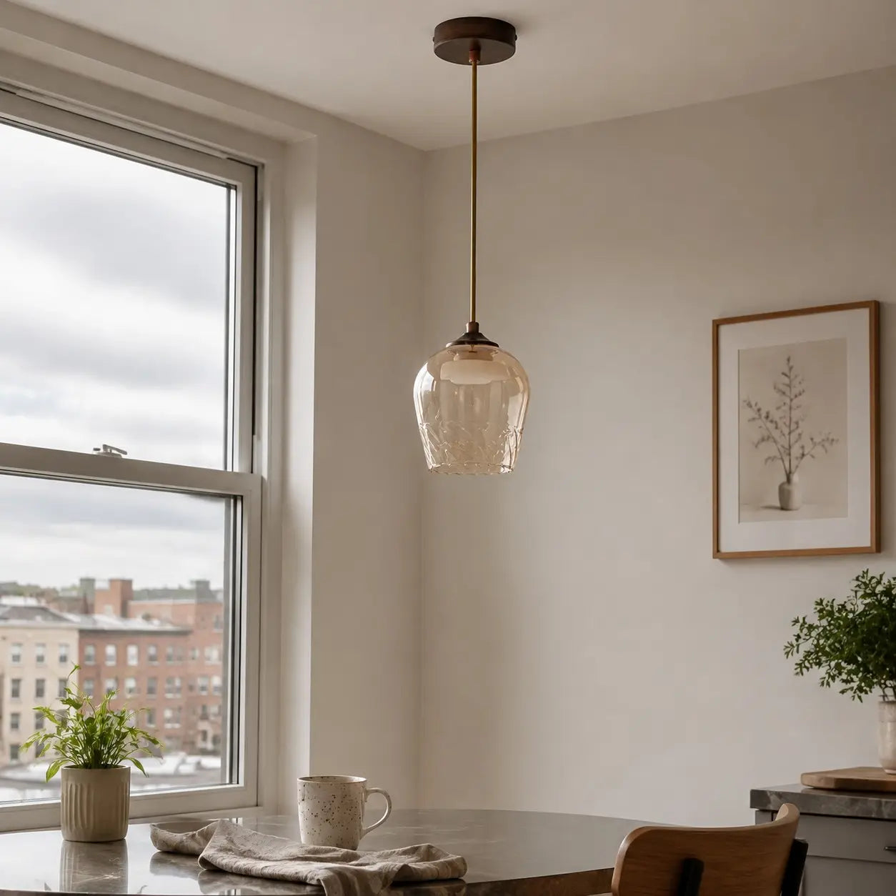 Amber glass pendant light in a warm window-side interior
