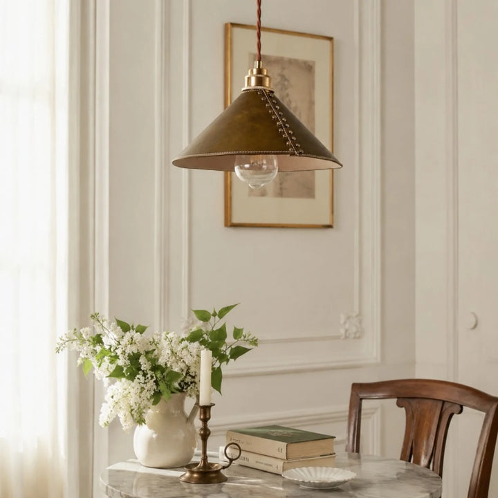 Brown leather pendant lamp above a vintage dining table