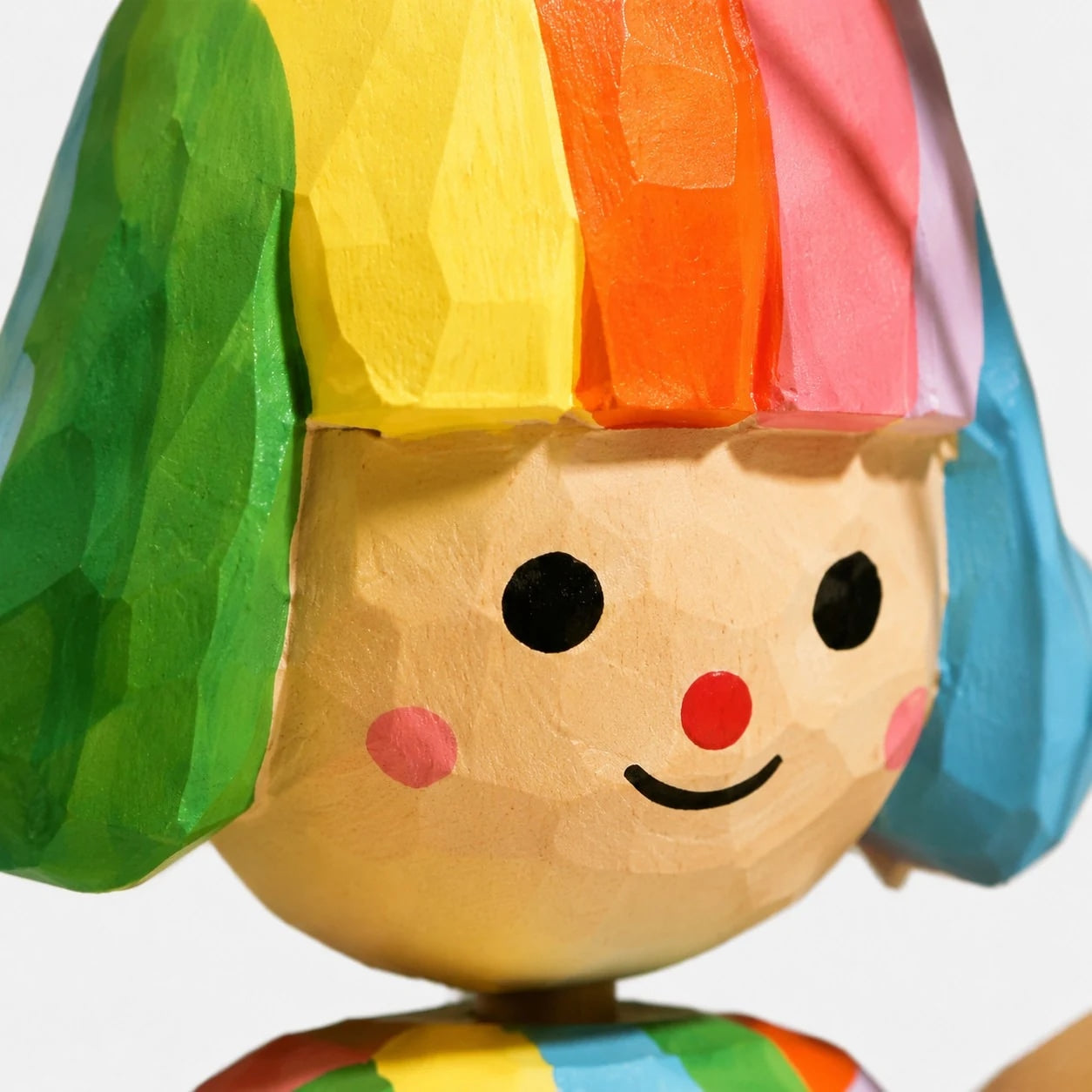 Painted face detail on wooden figurine