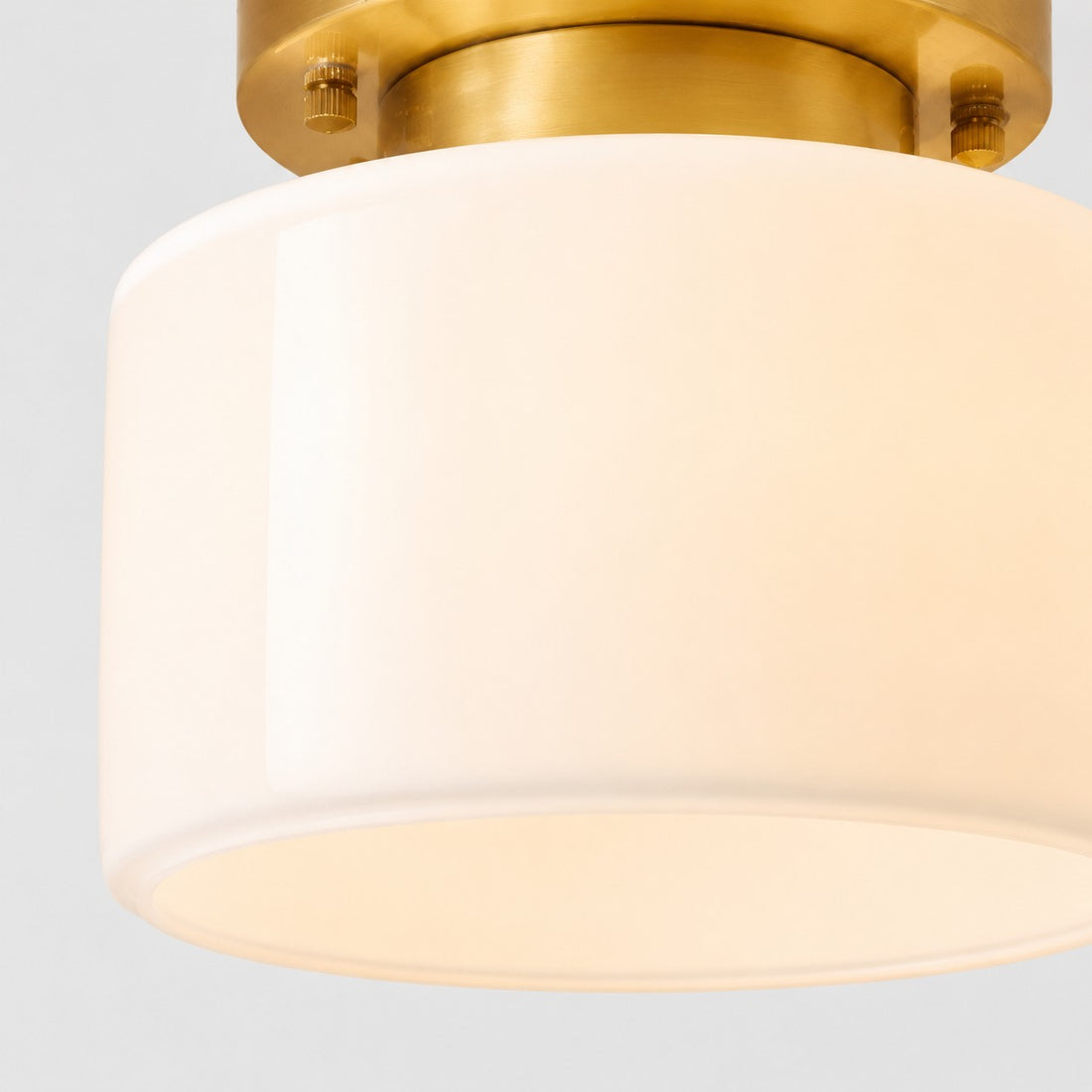 Close detail of frosted glass shade and brass ceiling plate