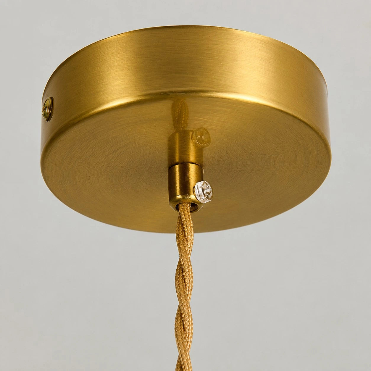 Close view of the brass-tone ceiling canopy and cord