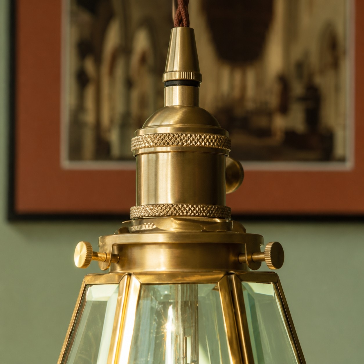 Close view of brass pendant cap and clear glass shade