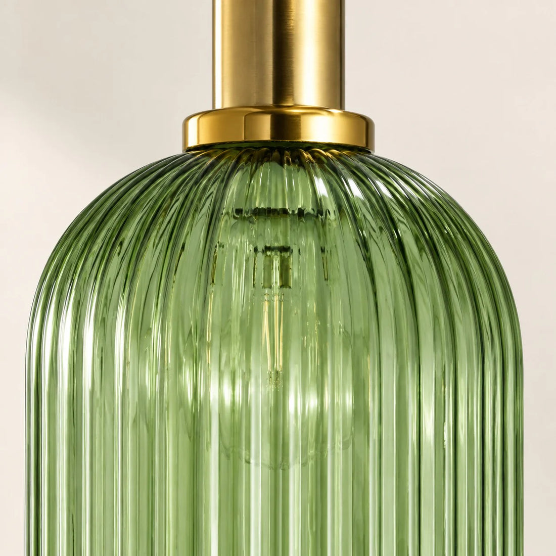 Close-up of green ribbed glass and brass-tone collar
