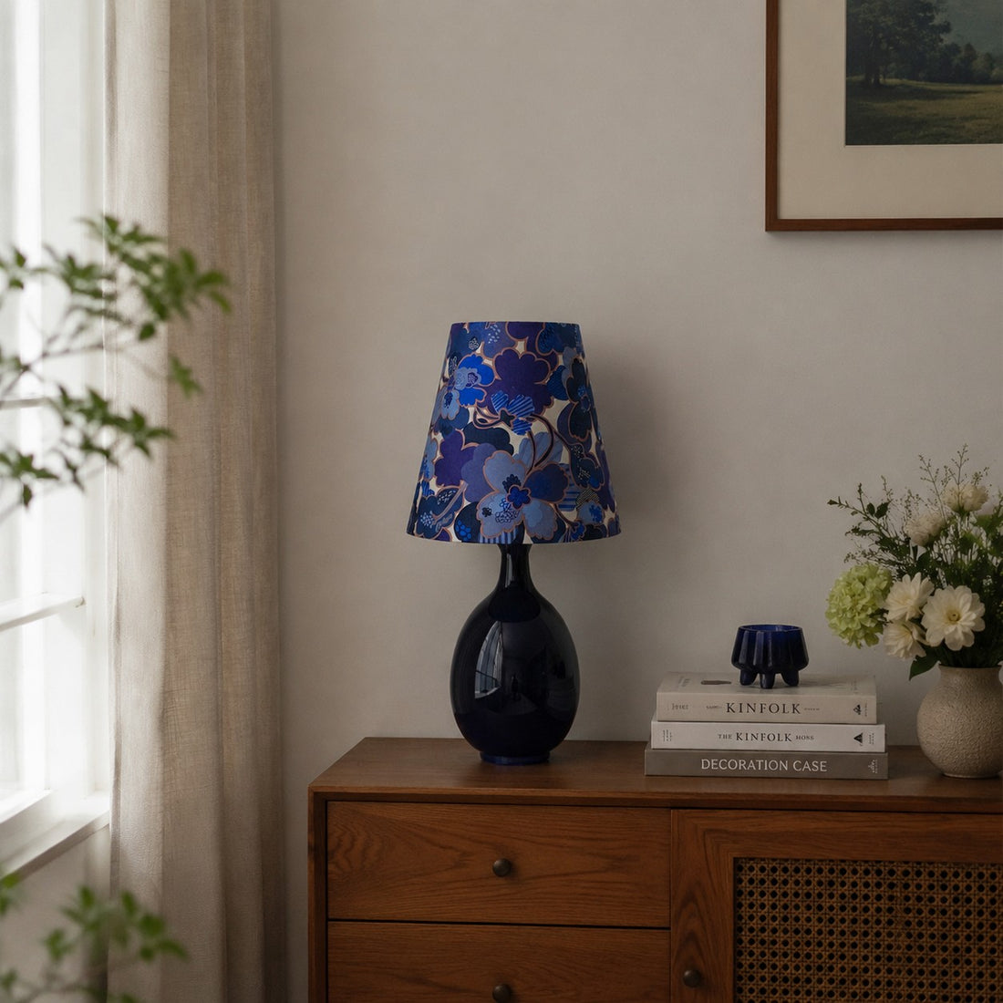 Blue floral fabric ceramic table lamp on a wooden cabinet