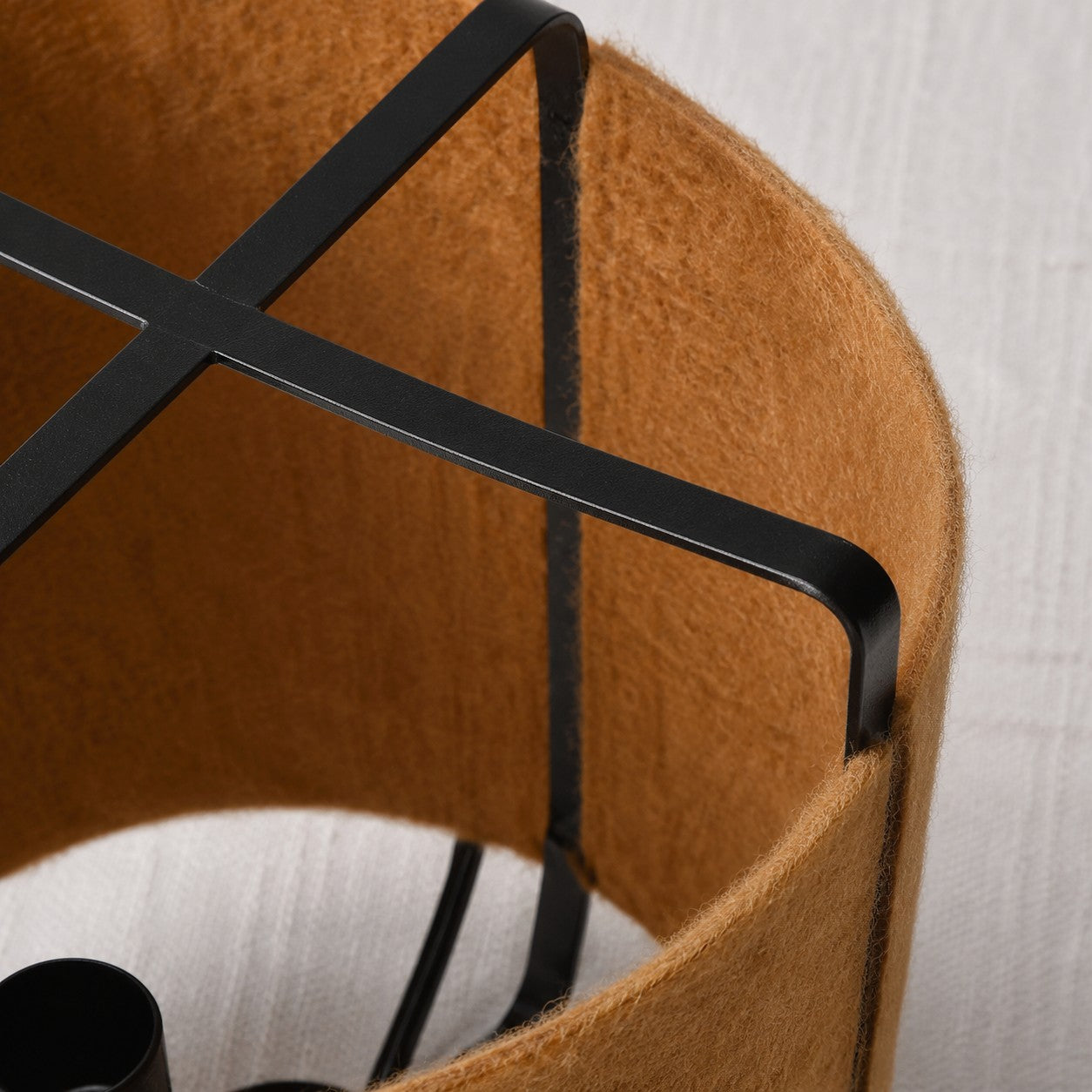close view of black metal frame and coffee fabric shade