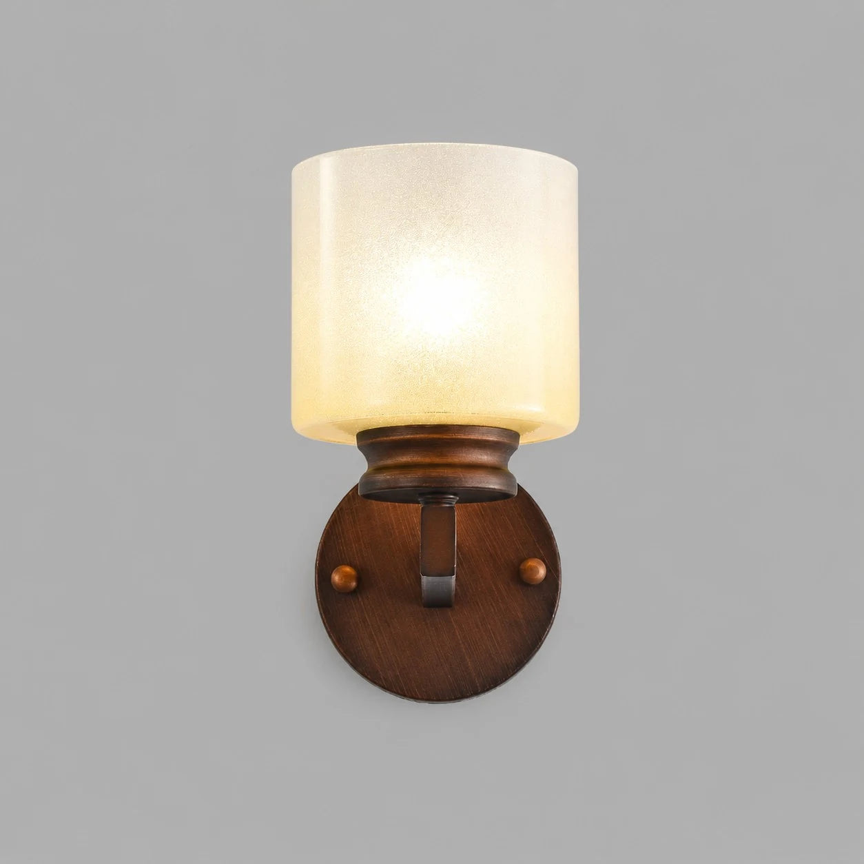 Front view of lit aged bronze alabaster glass wall sconce