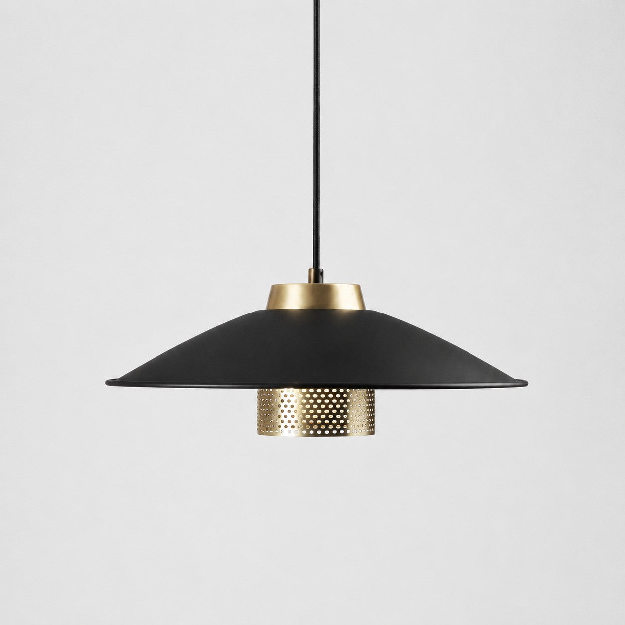 Black and antique brass metal pendant light with wide conical shade on a white background