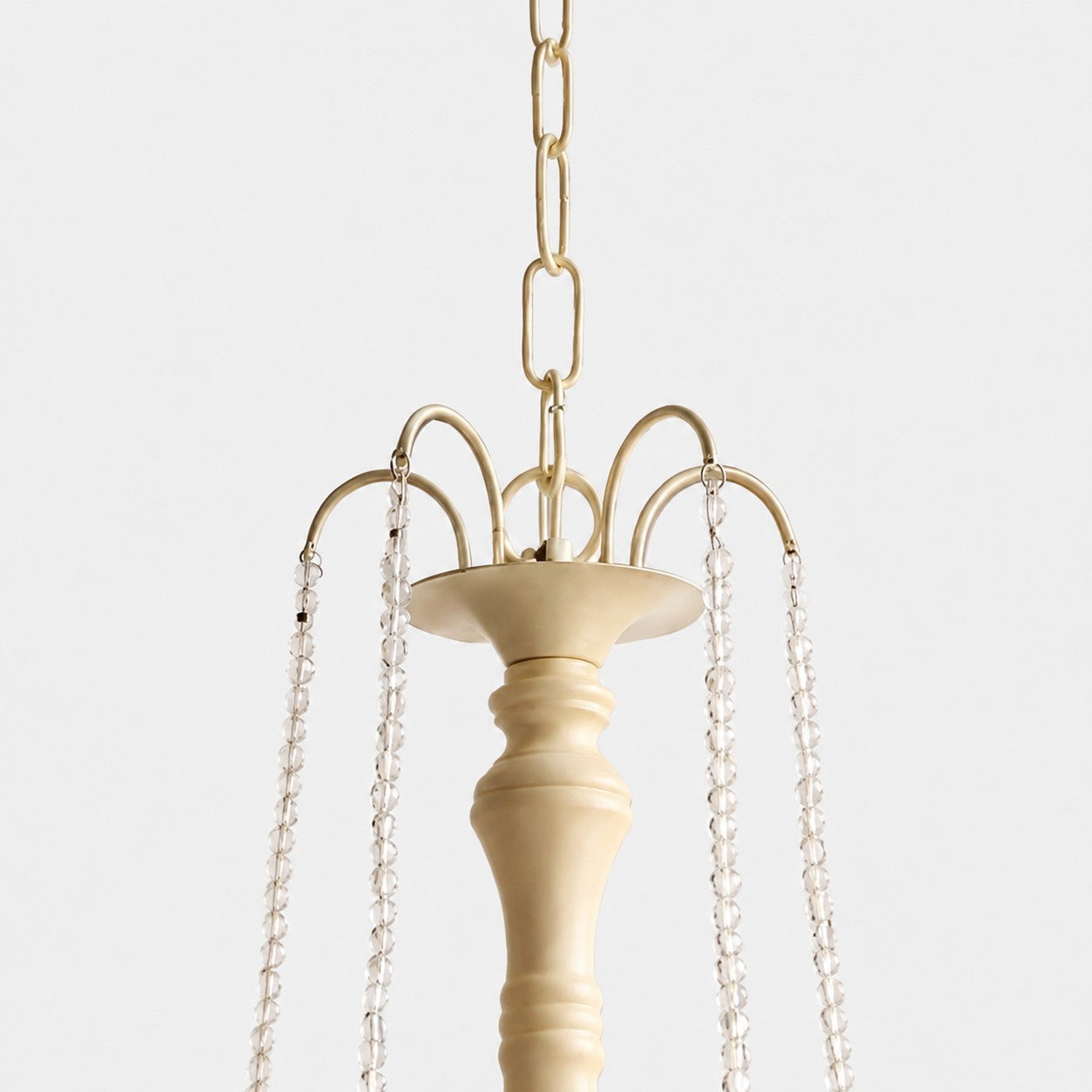 Close-up of gold-tone hanging chain and crystal bead suspension details