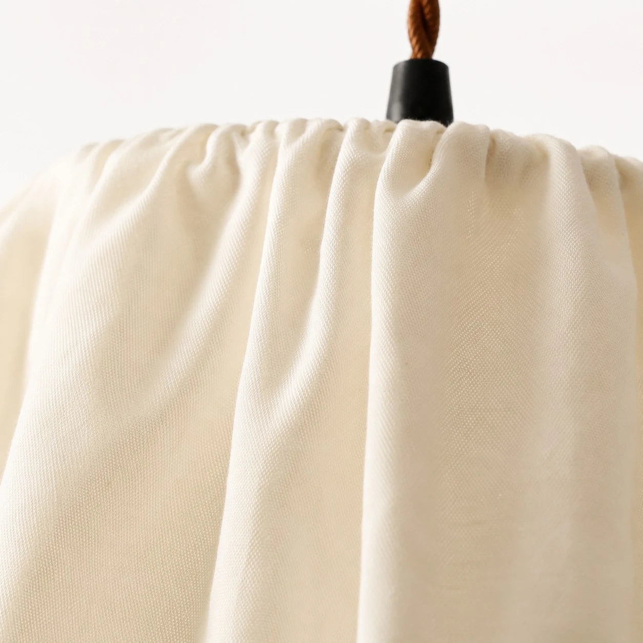Close view of the gathered ivory fabric shade texture