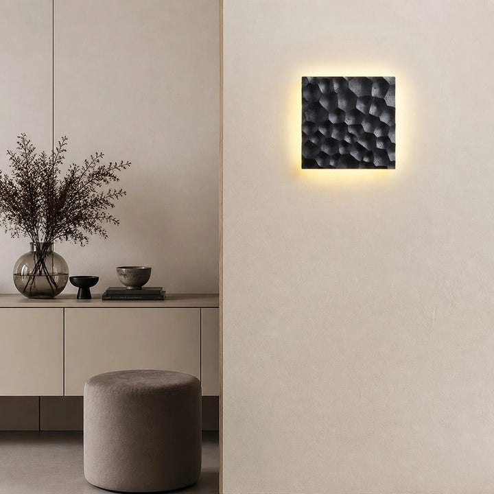 Ivory carved travertine wall sconce installed on a neutral wall