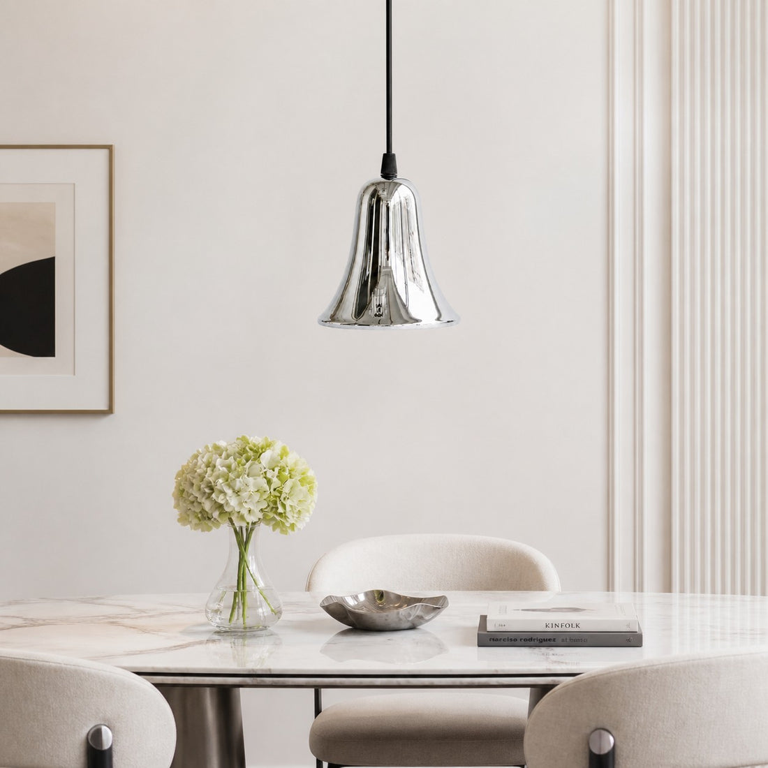 Bell-shaped chrome pendant light in a bright dining space