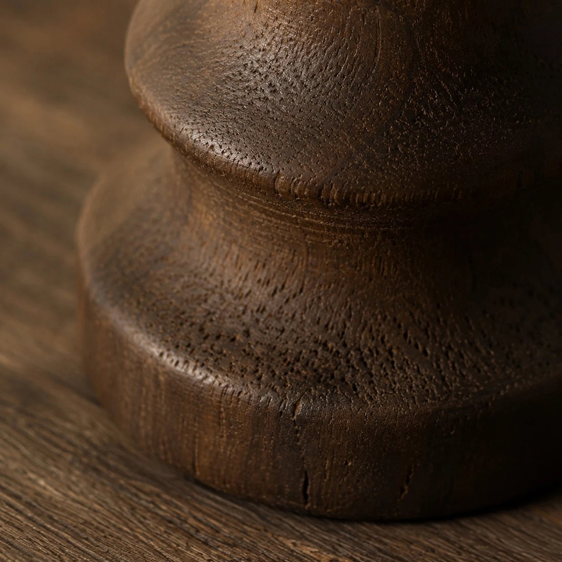 Close view of the dark carbonized wood base and turned contour