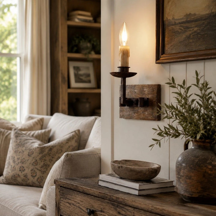 Single candle wall sconce mounted beside framed artwork