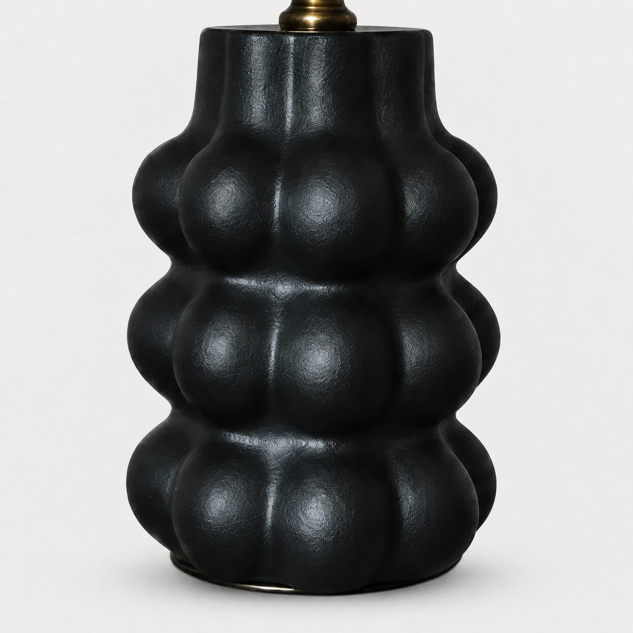 Sculpted matte black ceramic lamp base detail