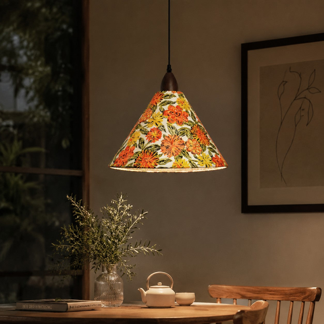 Orange floral pendant illuminating tea table in evening interior