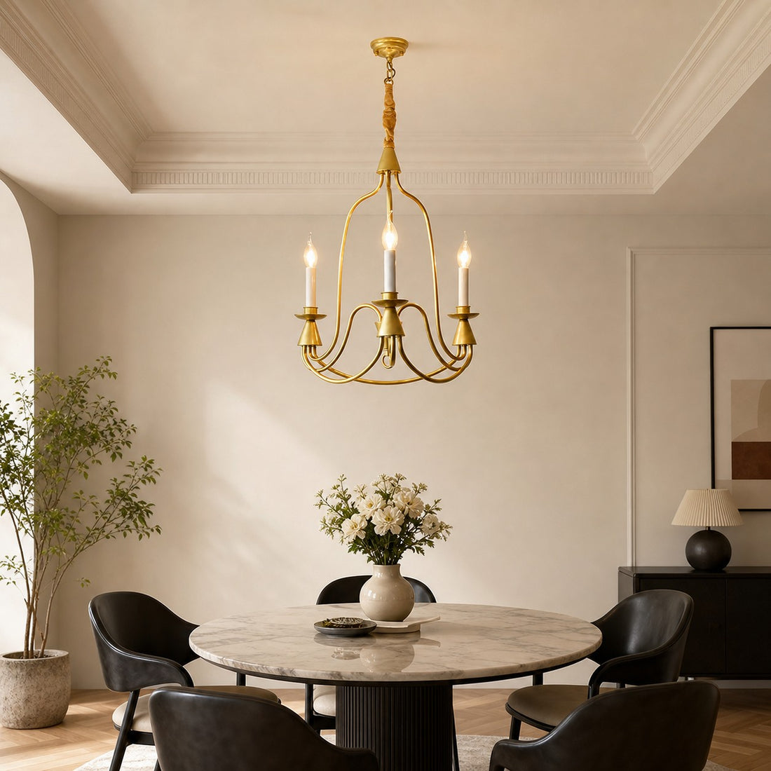 Gold three-light candle chandelier in a bright dining nook