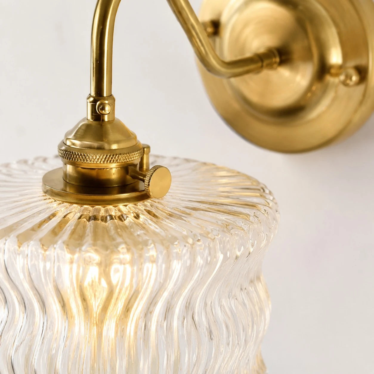 Close detail of clear ripple glass shade and brass fitter