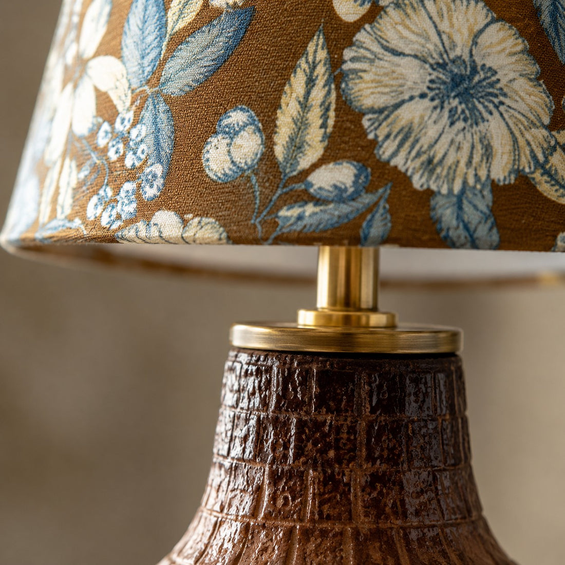 Close view of blue floral fabric lampshade and ceramic neck