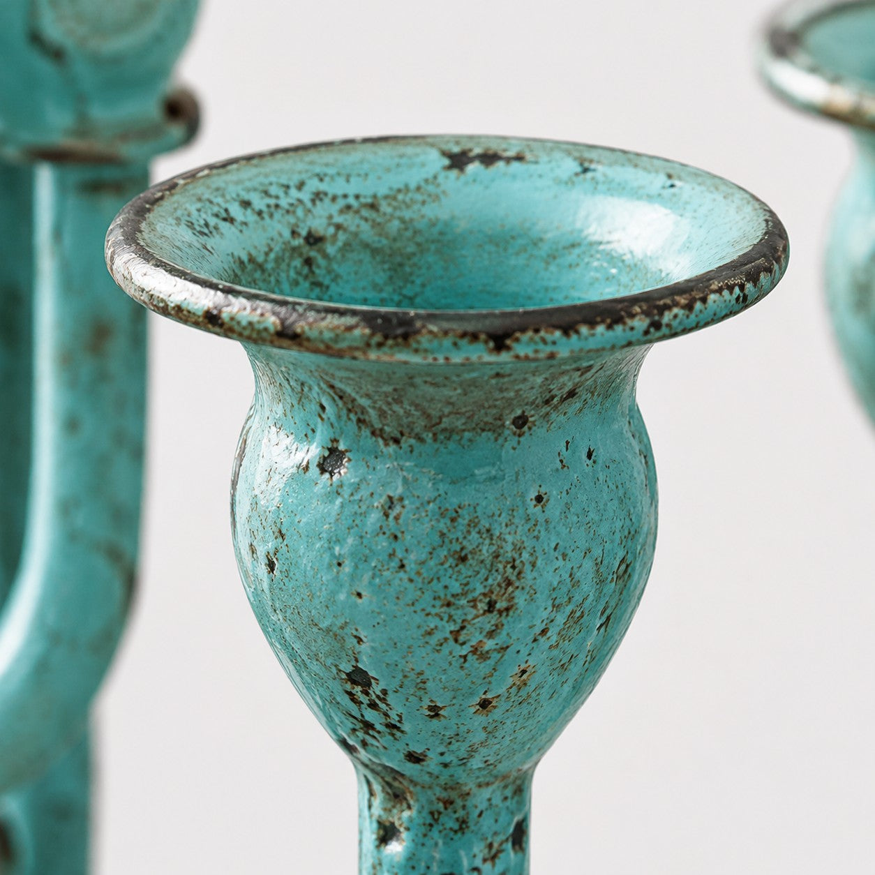 Close view of blue-green branch candle cup and patina