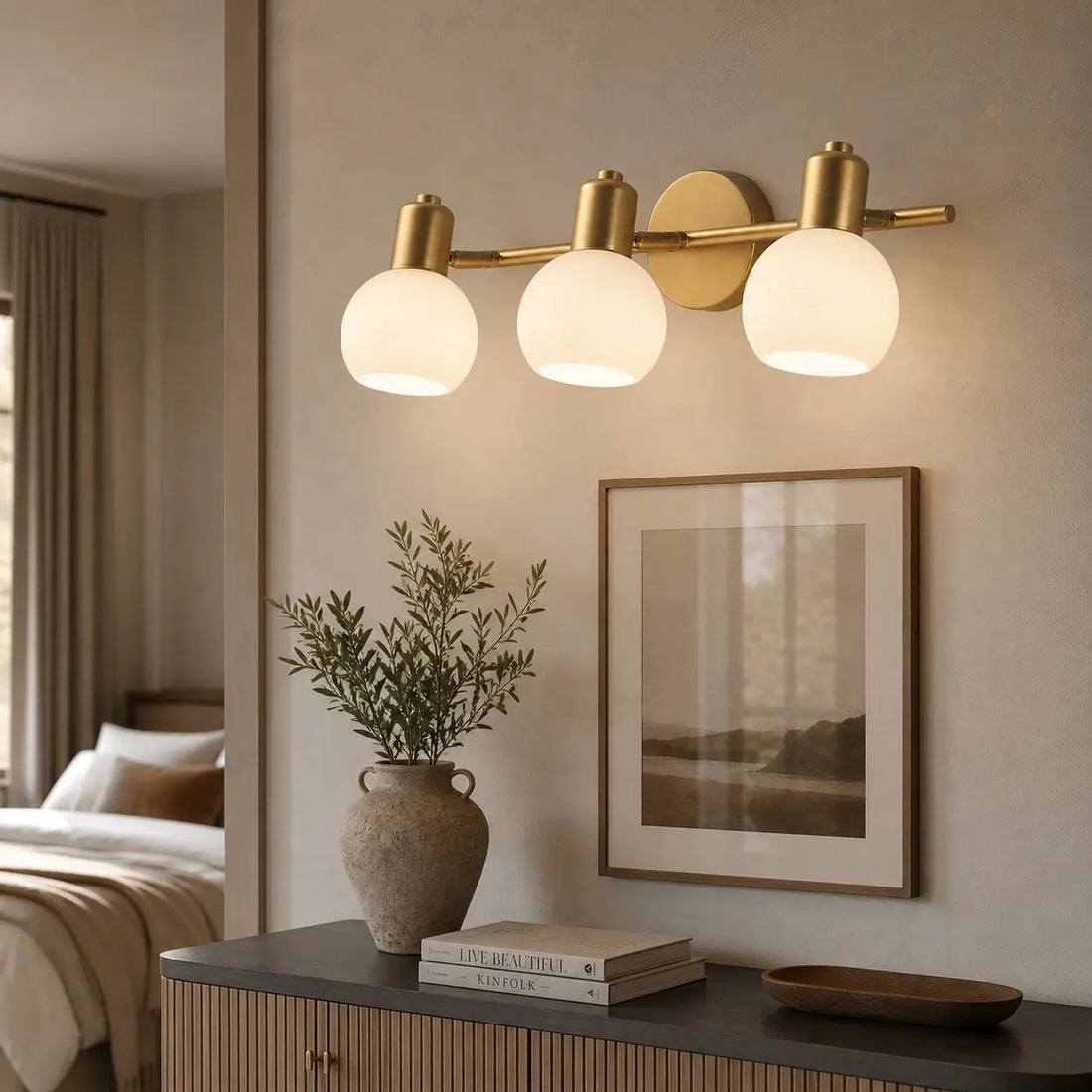 Three-light gold wall sconce in a refined hallway
