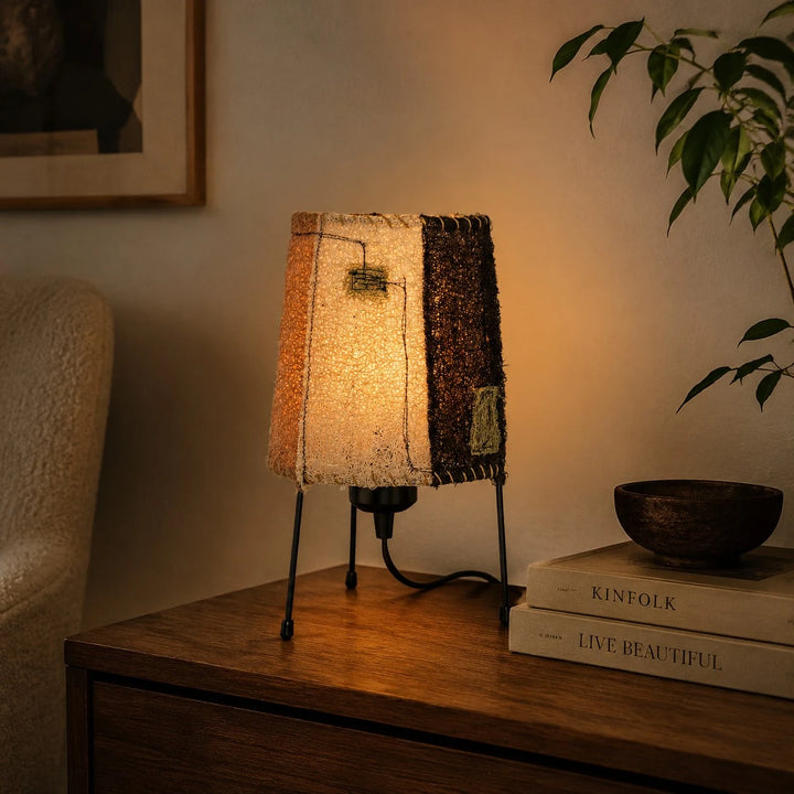 Natural woven fiber table lamp glowing on nightstand