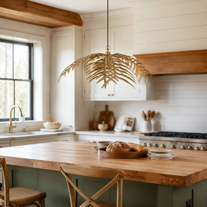 Single layer gold palm leaf chandelier above a kitchen island