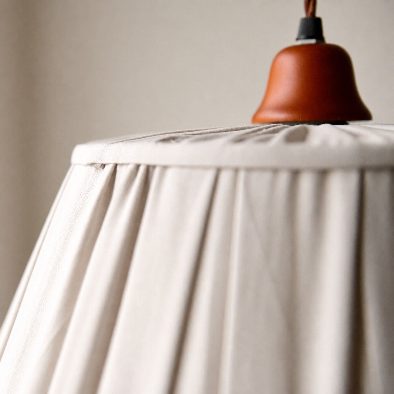 Upper shade detail with terracotta-tone cap and fabric folds