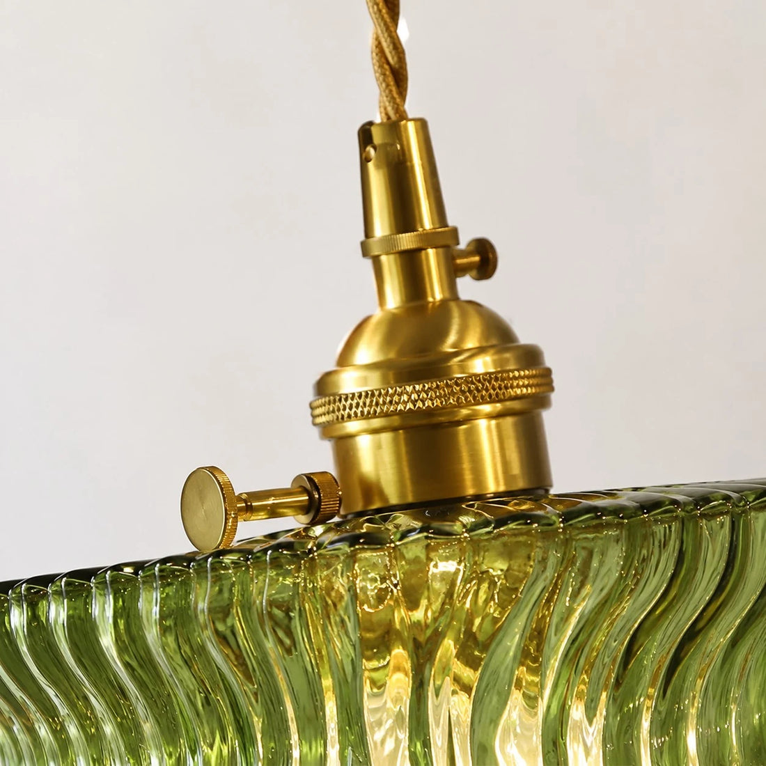 Close detail of olive ripple glass shade and knurled brass hardware