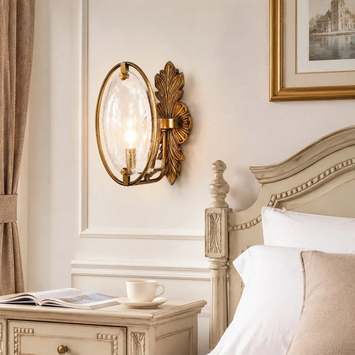 Antique brass textured glass wall sconce installed beside a bed
