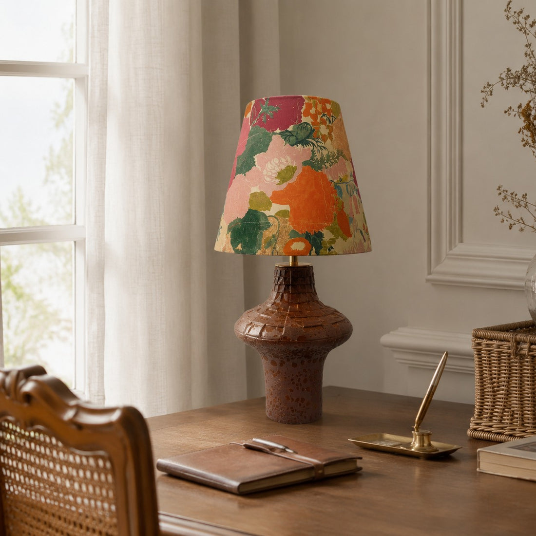 Orange floral ceramic table lamp on a writing desk