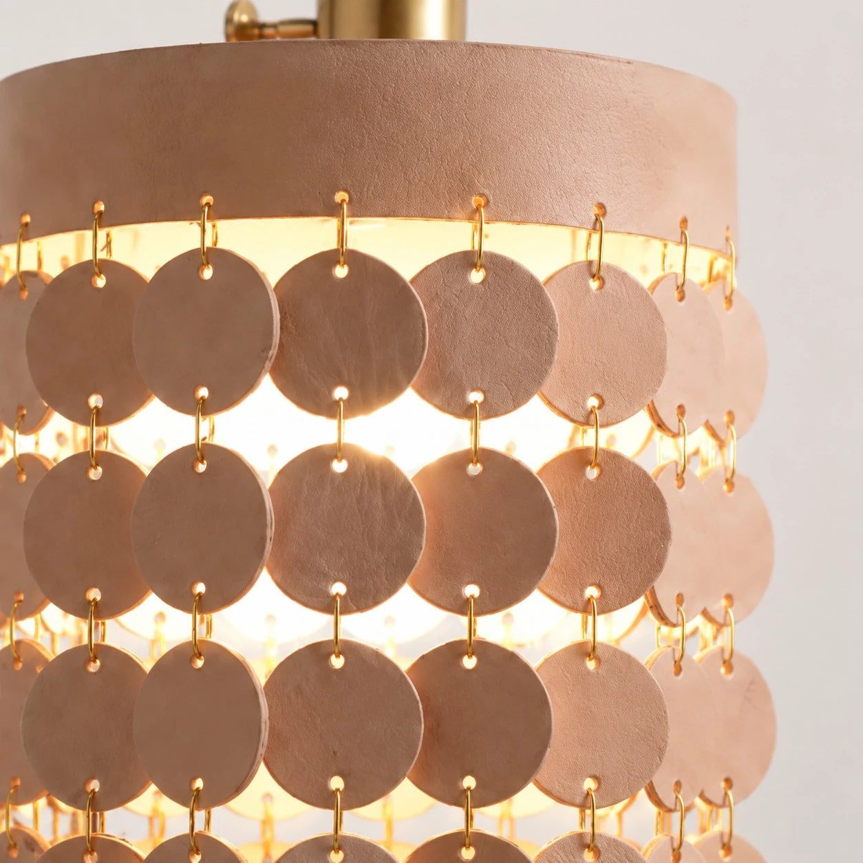 Layered leather discs joined with metal rings