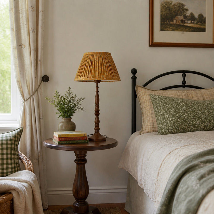 Floral pleated shade table lamp beside a bed