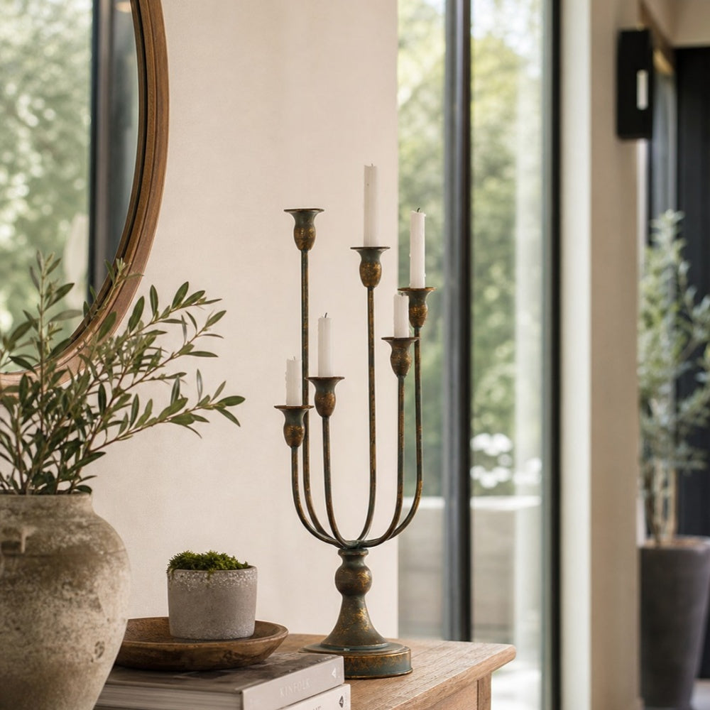 candle holder beside greenery and a mirror