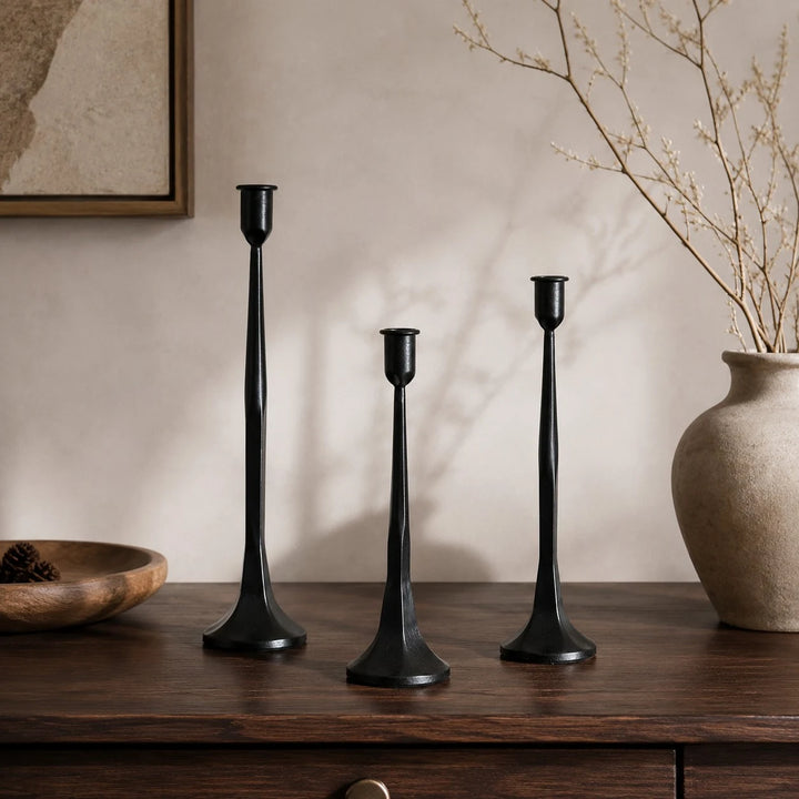Black iron candle holder set styled on a warm wabi-sabi console table