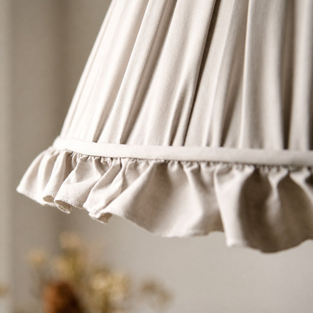Close view of the pleated fabric shade and scalloped trim