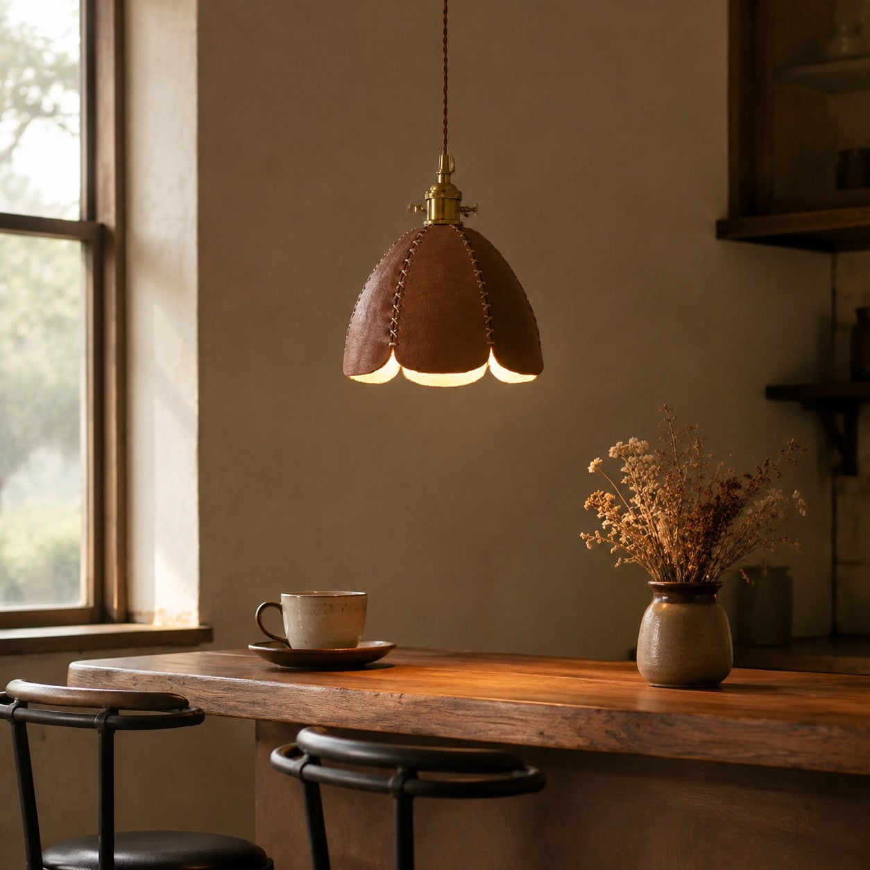 Brown leather petal pendant light above a warm desk corner