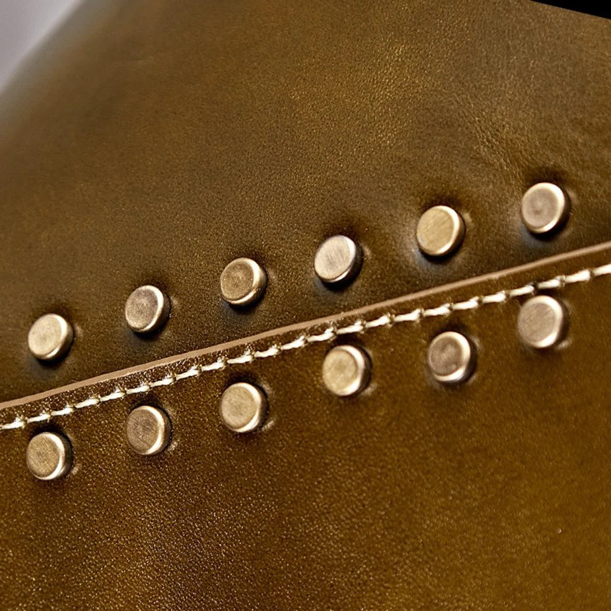 Close detail of brown leather shade with gold rivets